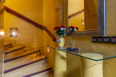 a bathroom with a mirror and a vase with flowers on a counter at Riad AZARO in Marrakech