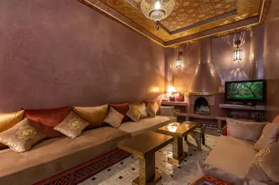 a living room with a couch and a tv at Riad AZARO in Marrakech