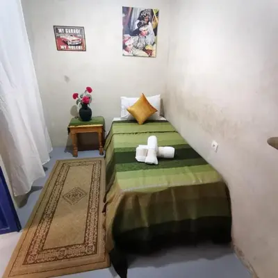 a bedroom with a bed with a teddy bear on it at RIAD DAR LFONOUN in Marrakech