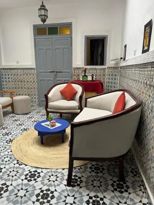 a living room with two chairs and a table at RIAD DAR LFONOUN in Marrakech