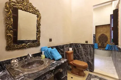 a bathroom with a sink and a toilet and a mirror at Riad Dwiriyat My Teib in Marrakech