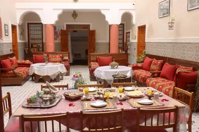 a living room with a table and a couch at Riad Dwiriyat My Teib in Marrakech