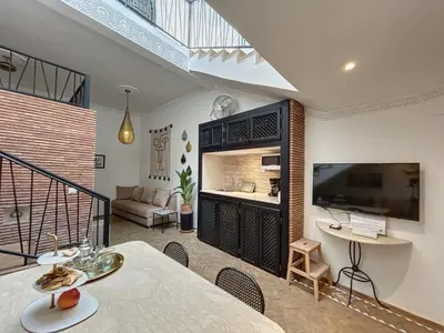 a living room with a dining table and a television at Riad Le Twenty 6 in Marrakech