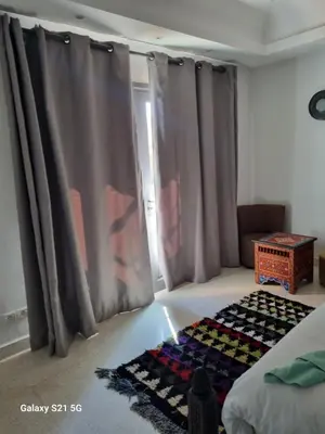 a bedroom with a bed and a rug on the floor at Riad les deux citronniers in Marrakech