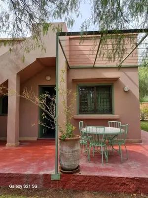 a patio with a table and chairs in front of a house at Riad les deux citronniers in Marrakech