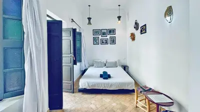a small bedroom with a bed and a chair at Riad Kadi in Marrakech