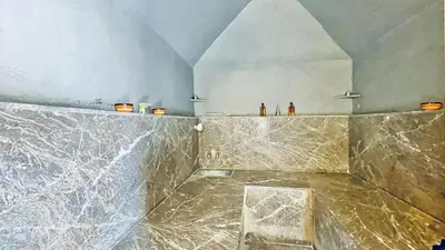 a bathroom with a marble counter top with a chair at Riad Kadi in Marrakech