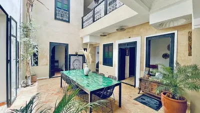 a dining room with a table and some plants at Riad Kadi in Marrakech