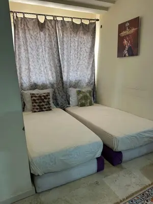 two beds in a room with a window at Appartement 33 in Marrakech