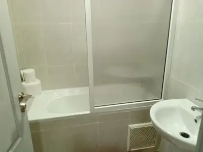 a white bathroom with a shower and a sink at Appartement 33 in Marrakech