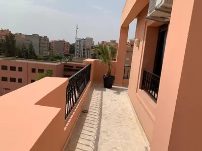 a balcony of a building with a potted plant at Victor hugo Appartement in Marrakech
