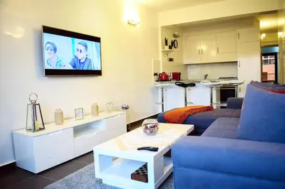 a living room with a couch and a tv on the wall at Apartment in Marrakesh, Gueliz in Marrakech
