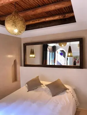 a bedroom with a white bed and a mirror at Riad Zahir in Marrakech