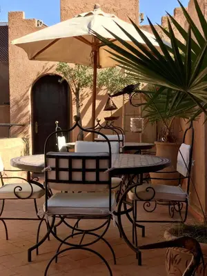 a table and chairs with an umbrella on a patio at Riad Zahir in Marrakech