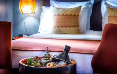 a tray of food on a table with a bed at Riad Tajania in Marrakech