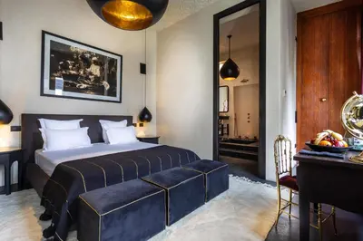a hotel room with a bed and a table and a desk at Riad Tajania in Marrakech