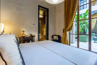 a bedroom with a bed and a large window at Riad Tajania in Marrakech