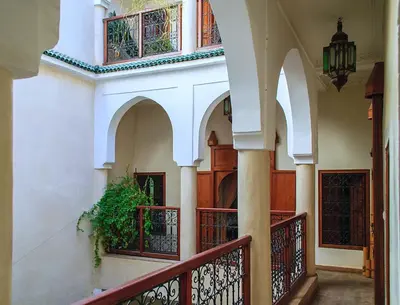 a building with a balcony with a plant on it at Riad Couleurs du Sud in Marrakech