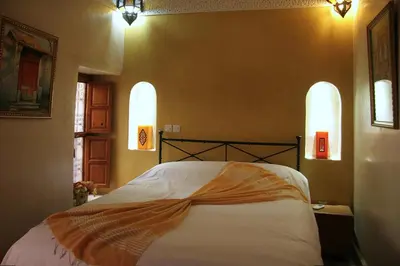 a bedroom with a large bed with two windows at Riad Couleurs du Sud in Marrakech
