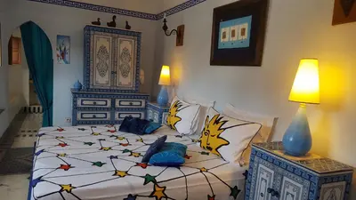 a bedroom with a large bed with colorful pillows at Riad Jenaï L'Authentique in Marrakech
