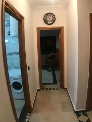 a hallway with a mirror and a clock on the wall at Annakil Appart in Marrakech