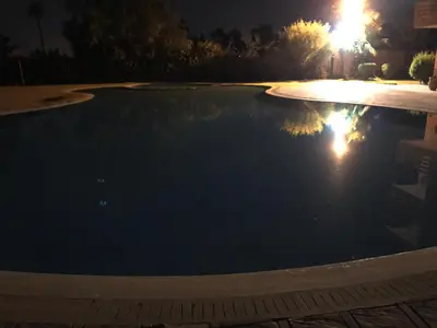 a swimming pool at night with the lights on at Annakil Appart in Marrakech