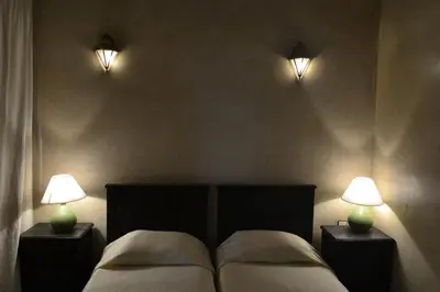 a bedroom with two beds with lights on the wall at Riad Charik in Marrakech