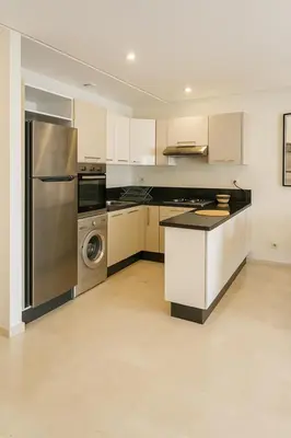 a kitchen with a stainless steel refrigerator and a dishwasher at Apt standing 80m2, 2 chambres, terrasse, piscine in Marrakech