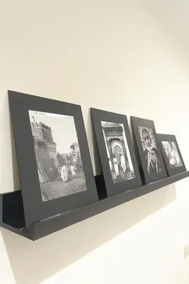 a shelf with four photos on it on a wall at Apt standing 80m2, 2 chambres, terrasse, piscine in Marrakech