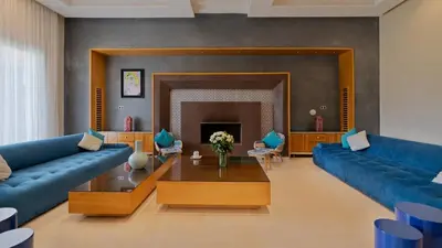 a living room with blue couches and a fireplace at Mimouna Riads in Marrakech