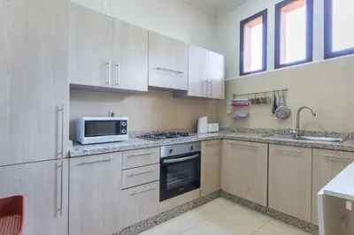a kitchen with white cabinets and a microwave at Villa Cosy - Jardin de l'Atlas - Golf & Waky in Marrakech