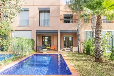 a house with a swimming pool in front of a building at Villa Cosy - Jardin de l'Atlas - Golf & Waky in Marrakech