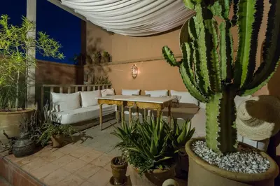 a living room with a table and a cactus at Riad El Maktoub in Marrakech