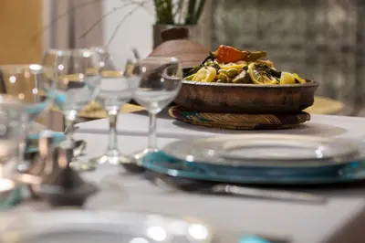 a table with a bowl of food and wine glasses at Riad El Maktoub in Marrakech