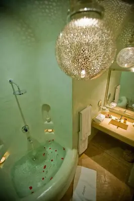 a bathroom with a tub and a chandelier at Riad Zamzam & Spa in Marrakech