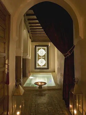 a bathroom with a tub with a window and a curtain at Riad Zamzam & Spa in Marrakech