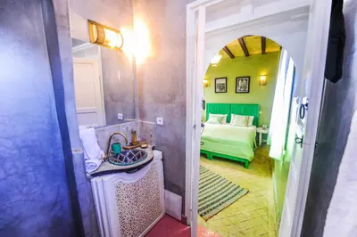 a bathroom with a sink and a room with a bed at Riad Milouda in Marrakech