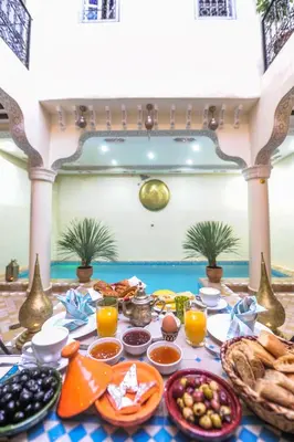 a breakfast table with food and drinks on a table at Riad Milouda in Marrakech