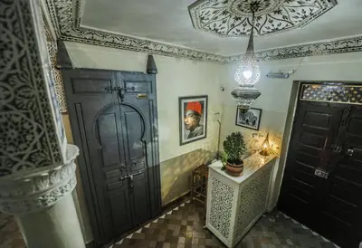 a hallway with a door and a potted plant on a table at Riad Milouda in Marrakech