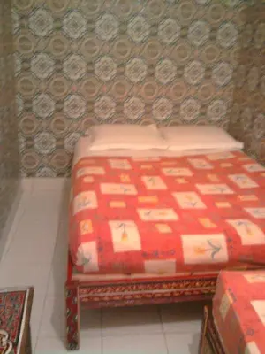 a bed sitting in a room with a red blanket at Hotel Aday in Marrakech