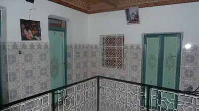 a balcony with green doors and tiles on the wall at Hotel Aday in Marrakech