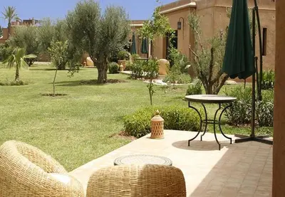 a patio with a table and chairs and an umbrella at Oasis Jena Marrakech in Marrakech