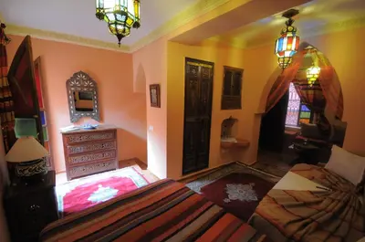a bedroom with a bed and a dresser and a mirror at Riad Basma Marrakech in Marrakech