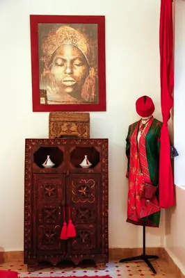 a statue of a woman on a wall next to a cabinet at Riad Dada Mouss & Suites in Marrakech