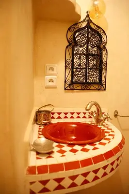 a bathroom with a red sink with a checkered counter at Riad Dada Mouss & Suites in Marrakech