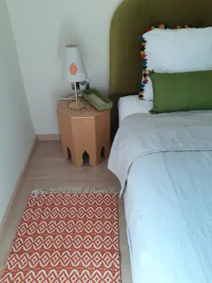 a bedroom with two beds and a table with a lamp at Jade Golf City in Marrakech