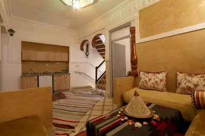 a living room with a couch and a kitchen at Riad Capri in Marrakech