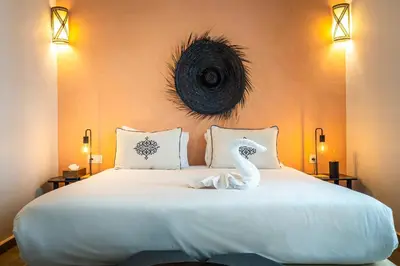 a bedroom with a white bed with a swan on it at Riad Come & Va Medina in Marrakech