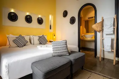 a bedroom with a bed and a chair and a tub at Riad Come & Va Medina in Marrakech