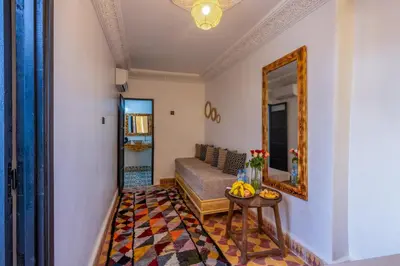 a living room with a bed and a mirror at Riad des remparts Marrakech in Marrakech